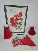 Full lot showing three Santa hats, two poinsettia tea towels and sealed snowman napkin pack
