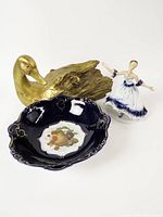 Overall view showing gold duck sculpture, cobalt bowl, and porcelain figurine