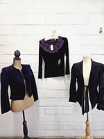 Full view of three purple garments on forms and hanger