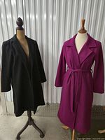 Black and fuchsia long coats on mannequins