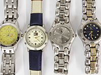All four watches side by side showing dials and bracelets/strap