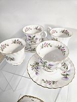 Four teacups and saucers showing pattern and gilt rims
