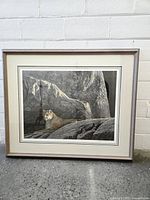 Framed cougar print front view against white brick