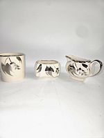 Three Sandland Ware porcelain pieces: tumbler, sugar bowl, creamer