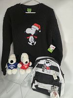 Group shot showing sweater, backpack, two plush toys and keychain