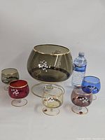 Full set showing bowl and five colored snifters with water bottle for scale