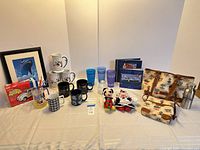 Full lot overview showing bags, drinkware, books, plush, model kit, print, bottle