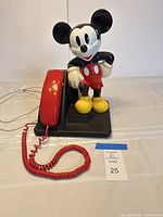 Front view of Mickey Mouse telephone with handset on base