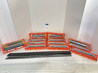 Twelve boxed Rivarossi HO passenger cars and straight track displayed