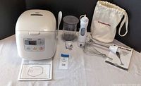 Overall lot showing rice cooker, blender parts, accessories and manuals