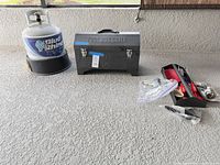 Grill closed, propane tank, utensils in bags