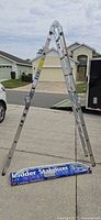 Ladder fully opened in A-frame position with stabilizer bar on ground