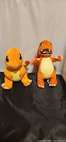 Both Charmander plush toys side by side front view