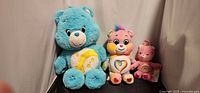 Three Care Bears plush toys standing side by side