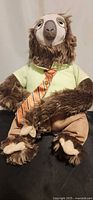 Full view of Flash the Sloth plush seated