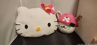 Front view of Hello Kitty pillow and MAC pirate cat plush