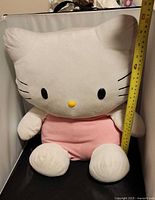Front view of Hello Kitty plush with measuring tape showing height
