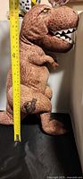 Side view of full plush with measuring tape showing height
