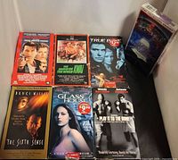 Seven VHS tapes laid out showing front covers