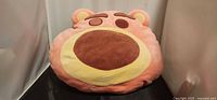 Front view of round Lotso plush pillow showing face details