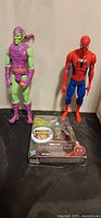All three items together: loose Spider-Man and Green Goblin figures standing, Mysterio figure in packaging lying in front