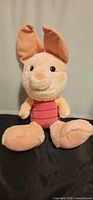 Front view of Piglet plush seated upright