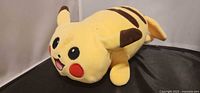 Front angled view of Pikachu plush showing face and body