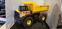 Left front view of Tonka Mighty Dump Truck showing cab, dump bed and wheels
