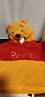 Front view showing embroidered “Pooh” and hood with bear ears