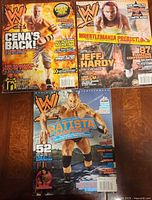 Three WWE Magazine issues laid out showing covers