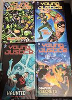 Group shot of all four Young Justice hardcover books