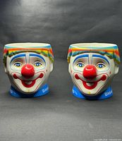 Front view of both clown face mugs