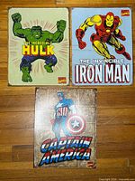 Front view of all three Marvel metal signs laid out Hulk, Iron Man, Captain America