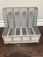 Front view of grey plastic desk file organizer showing four compartments