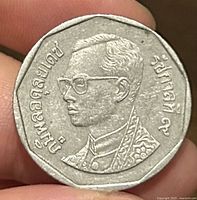 Obverse portrait of King Bhumibol Adulyadej with Thai script on dodecagonal coin