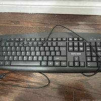 Top view of black wired keyboard with USB cable