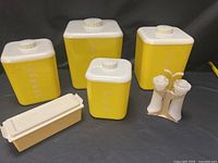 Group shot of four canisters, salt & pepper shakers in stand, butter dish