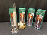 assembled silver-finish candle lamp with three boxed units behind