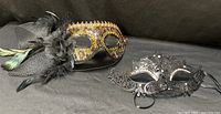 Both Venetian-style masks side by side on black backdrop