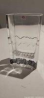 Front view of clear rectangular Iittala vase showing wavy band and brand mark