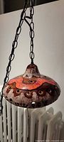 Full view of glazed ceramic pendant lamp hanging from metal chain