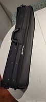 Closed black rectangular violin case on table