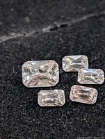 Five loose rectangular cubic zirconia stones on black background
