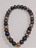 Entire bracelet shown in oval form displaying all pearl beads