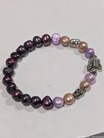 Full view of bracelet showing multicolour pearls and silver-tone charms