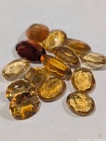 Cluster of loose oval citrine gemstones on white background