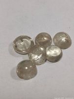 Six round pale gemstones on white background