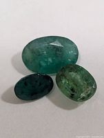 Three oval emeralds grouped on white background