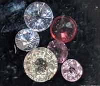 Close-up of all six round sapphires showing colors and faceting