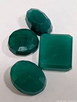four green agate stones on white background
